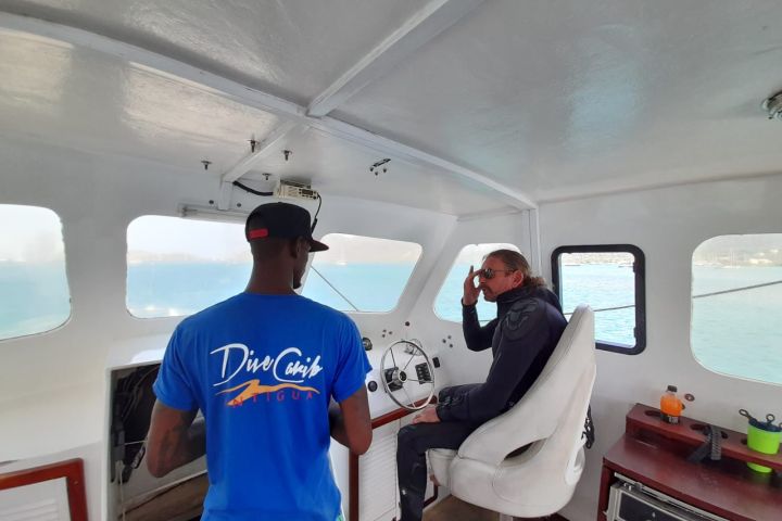 two crew members inside the boat wheelhouse