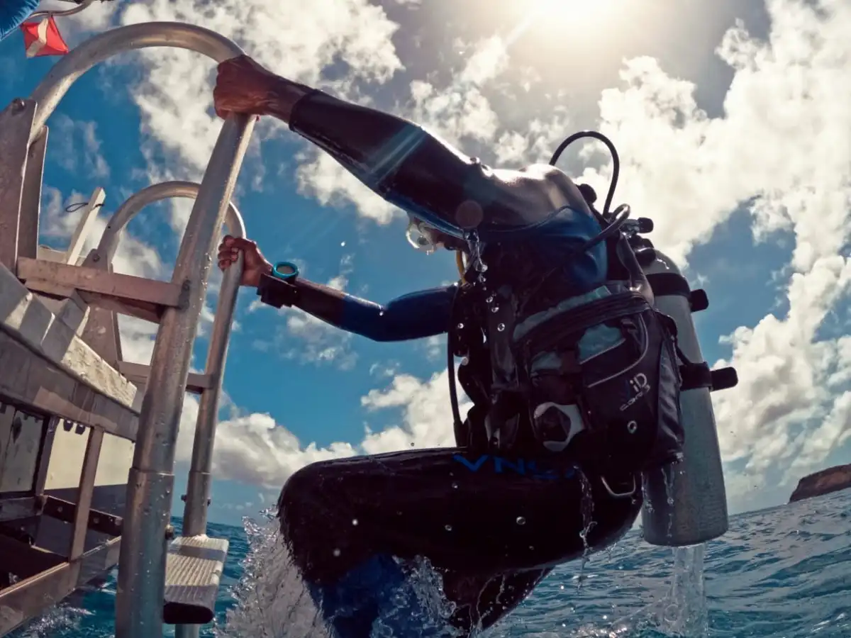 a scuba diver boarding the boat ladder