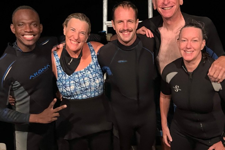a group of people posing for a photo after a night dive